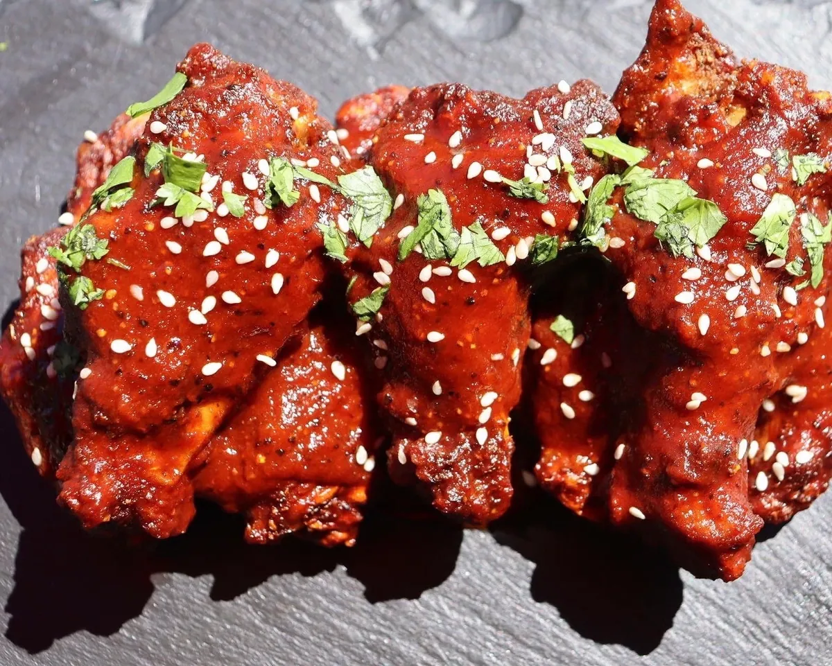 Glazed Peruvian-style chicken topped with sesame seeds and cilantro